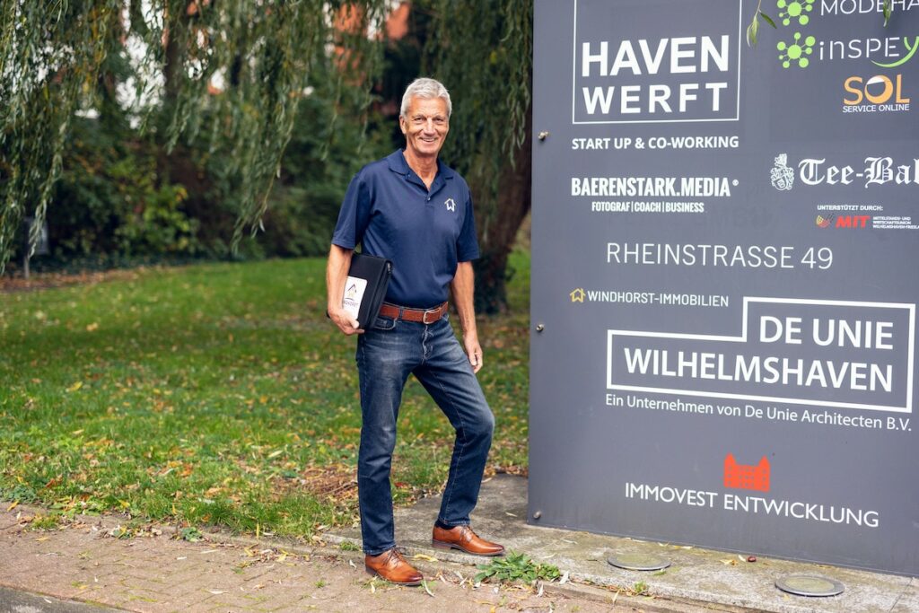 Volker Windhort vor dem Werbeschild der Havenwerft in Wilhelmshaven